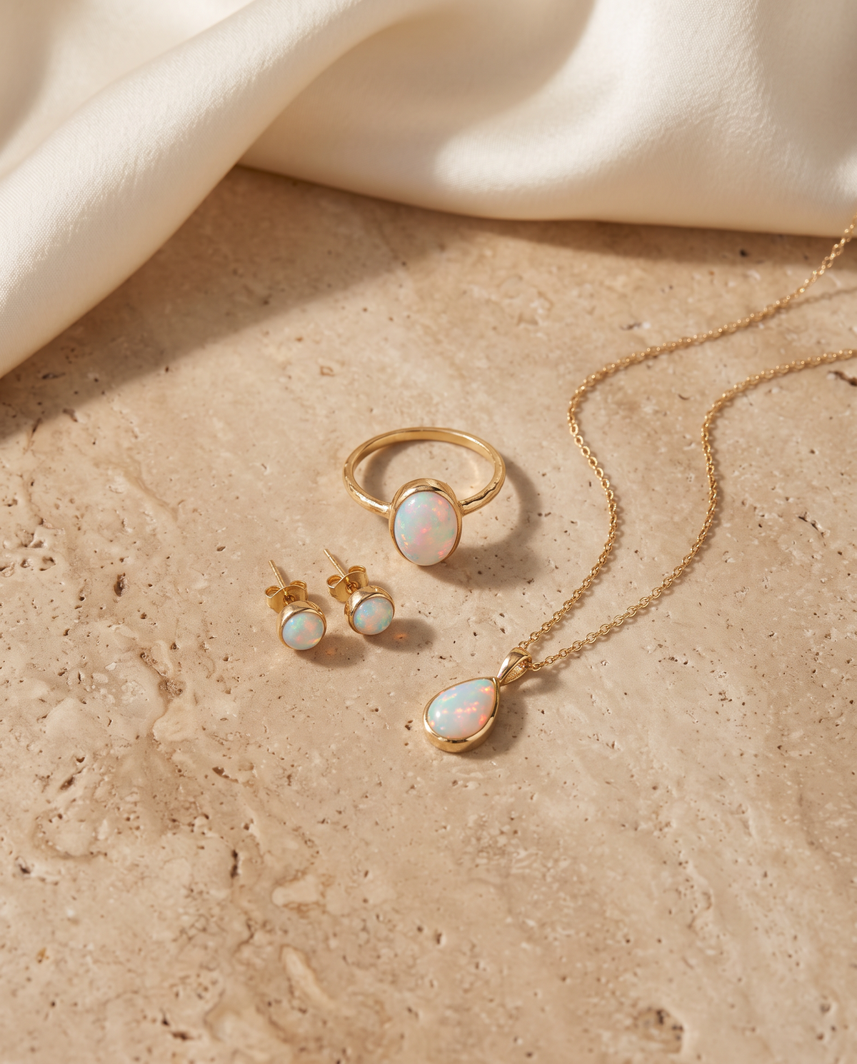 Tess & Mae Opal Jewelry on warm beige travertine
