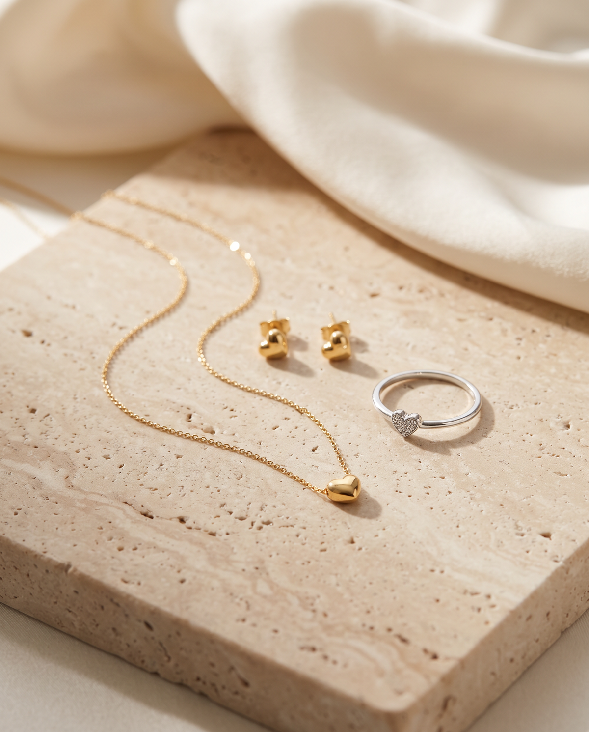 Tess & Mae Heart Jewelry on warm beige travertine