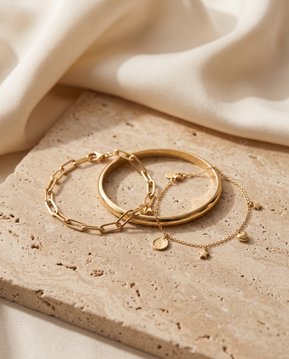 Tess & Mae Gold Bracelets on warm beige travertine